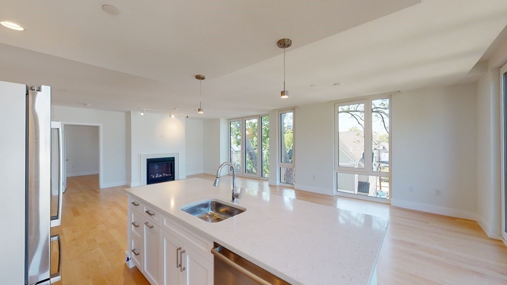 7 Beech Street, Unit 211 Cambridge, MA 02140 - Photo 3 of 7 a kitchen with stainless steel appliances granite countertop a sink a stove and a refrigerator
