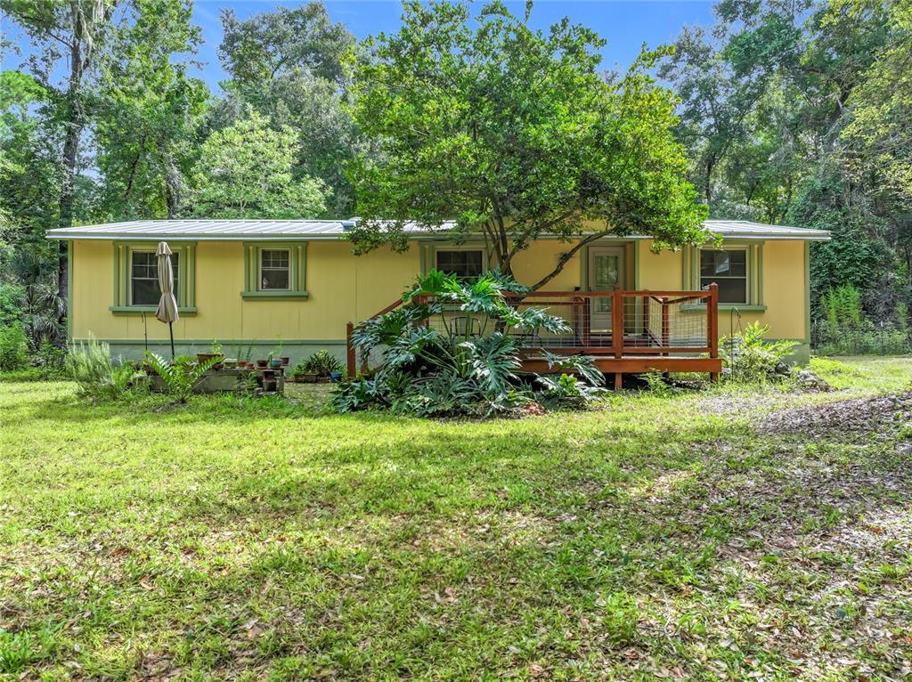 16303 Southwest 75th Street Archer, FL 32618 - Photo 1 of 1 a front view of a house with garden