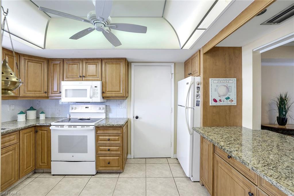 12 Watercolor Way, Unit 12 Naples, FL 34113 - Photo 12 of 35 a kitchen with a stove oven and cabinets