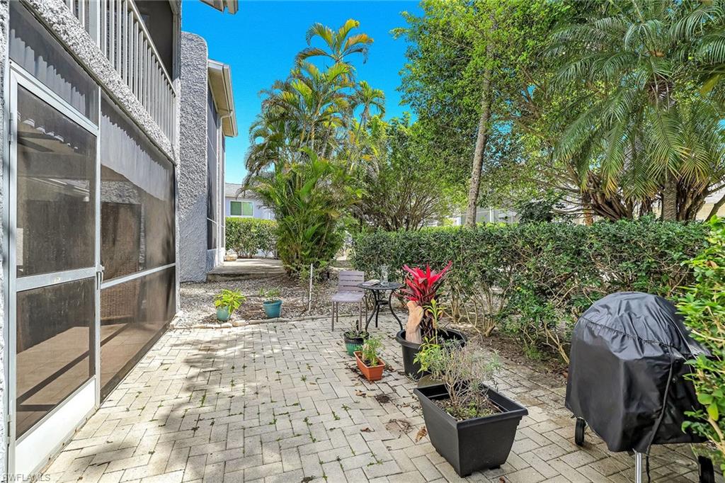 12 Watercolor Way, Unit 12 Naples, FL 34113 - Photo 18 of 35 a view of a patio with table and chairs potted plants