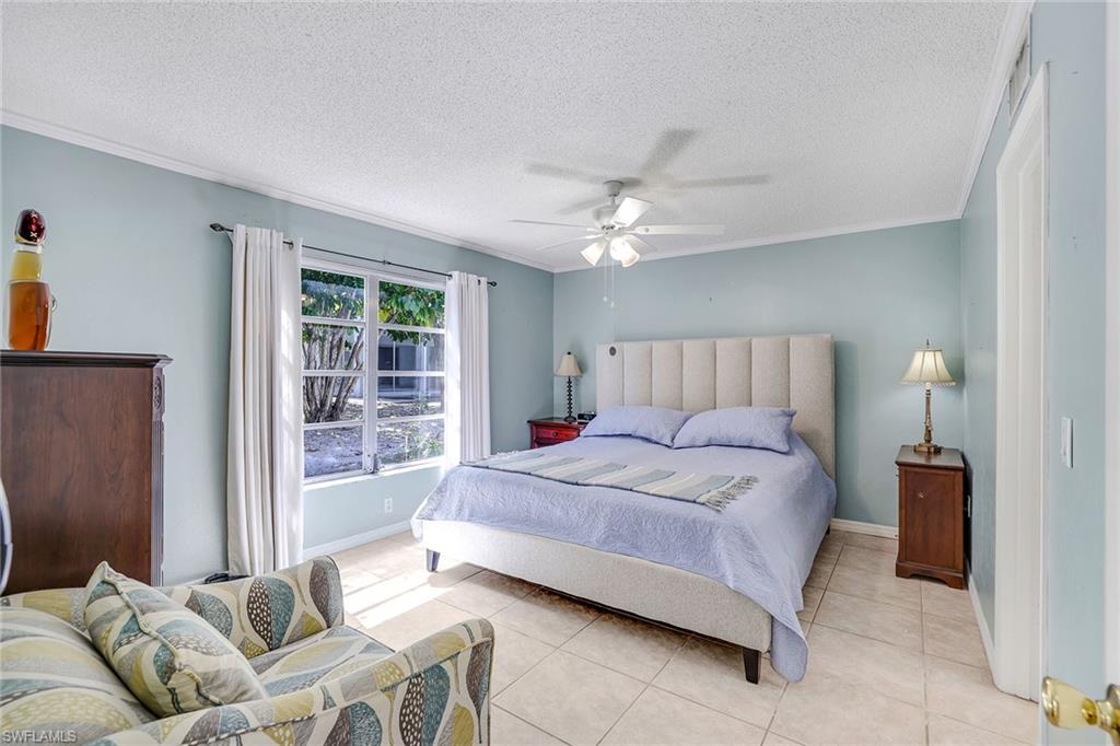12 Watercolor Way, Unit 12 Naples, FL 34113 - Photo 20 of 35 a bedroom with a bed and glass window