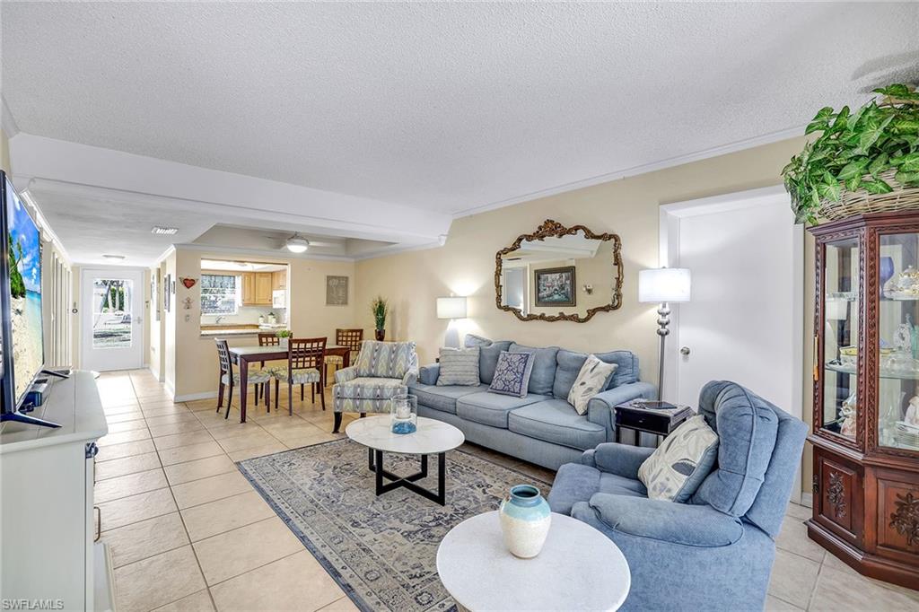 12 Watercolor Way, Unit 12 Naples, FL 34113 - Photo 6 of 35 a living room with furniture and a dining table with wooden floor