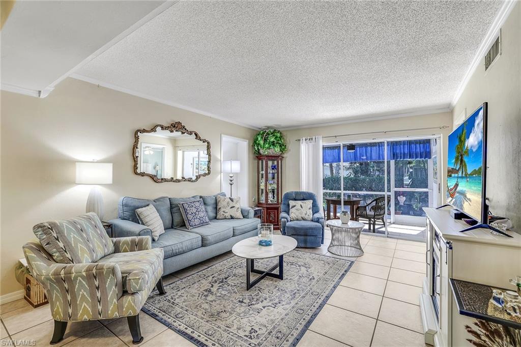 12 Watercolor Way, Unit 12 Naples, FL 34113 - Photo 7 of 35 a living room with furniture and a flat screen tv