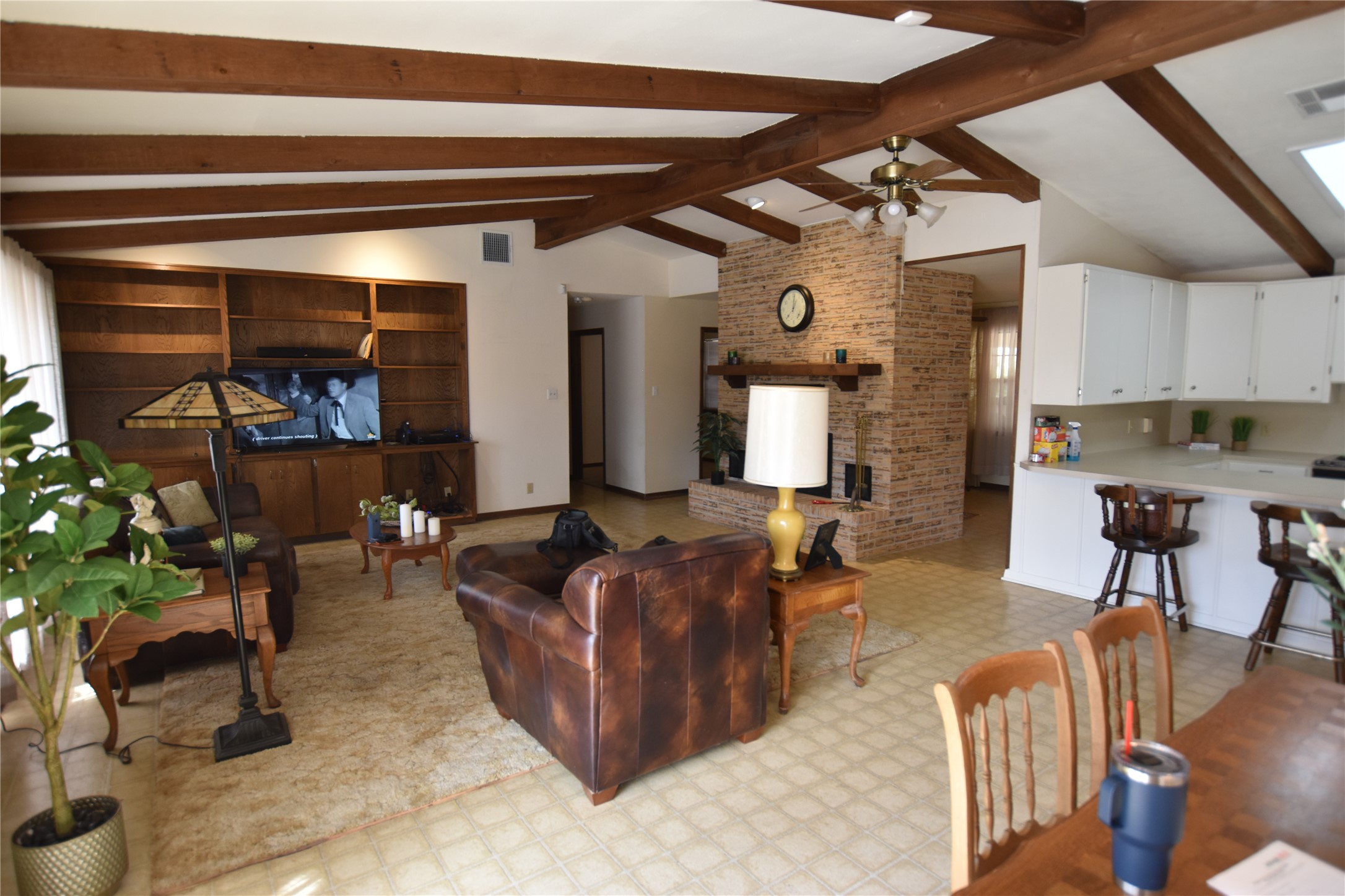 687 Fm 812 Road Red Rock, TX 78662 - Photo 35 of 40 Living room with light floors, beamed ceiling, a ceiling fan, and a fireplace