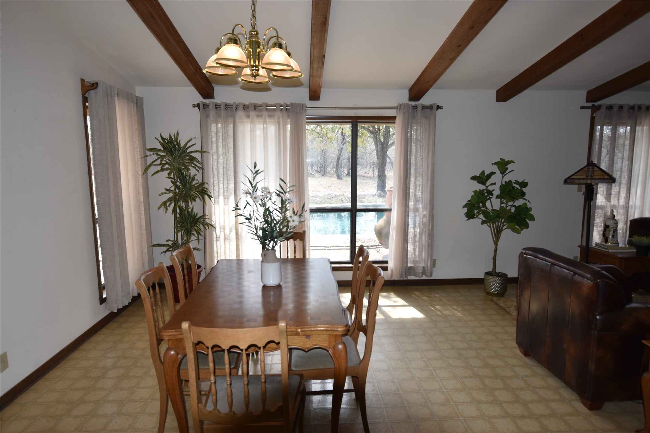 687 Fm 812 Road Red Rock, TX 78662 - Photo 38 of 40 Dining room featuring suspended lighting, light flooring, beamed ceiling, and plenty of natural light