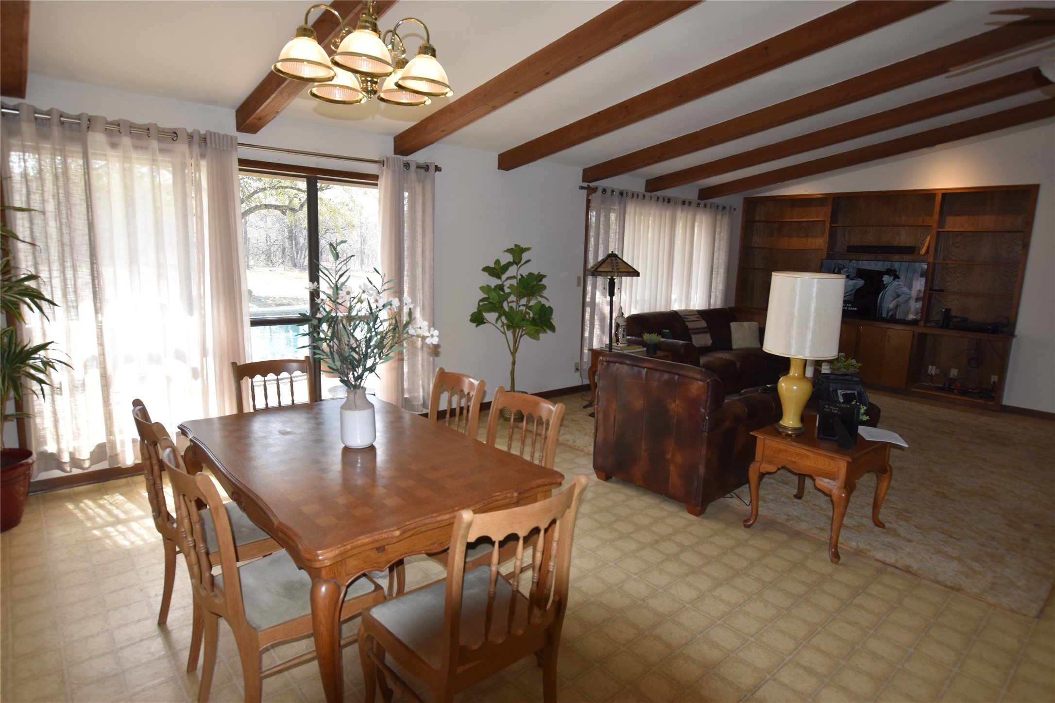 687 Fm 812 Road Red Rock, TX 78662 - Photo 39 of 40 Dining room featuring light flooring, hanging lights, plenty of natural light, and lofted ceiling with beams