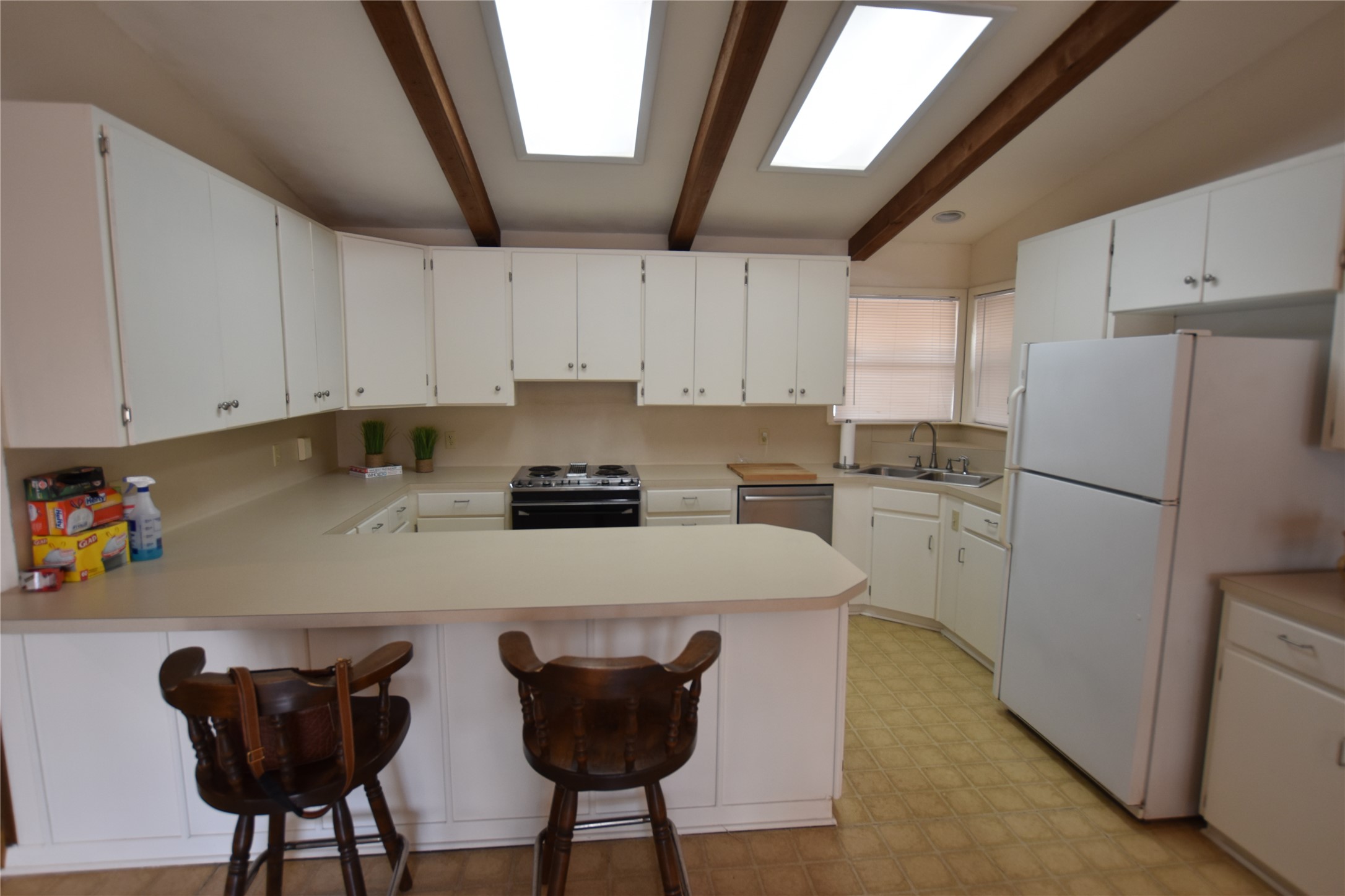 687 Fm 812 Road Red Rock, TX 78662 - Photo 6 of 40 Kitchen with wood beamed ceilings, light countertops, electric range oven, and a kitchen breakfast bar