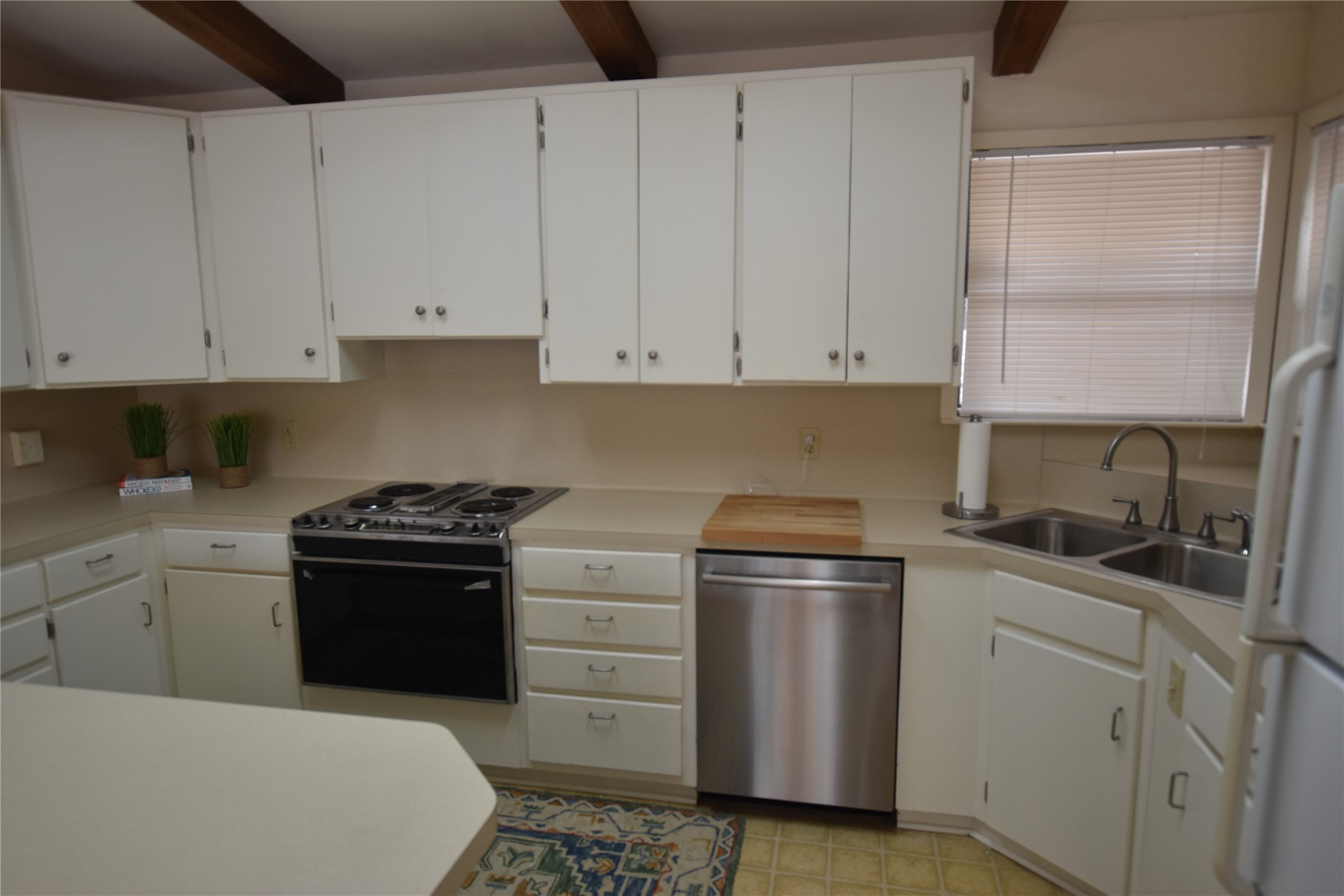 687 Fm 812 Road Red Rock, TX 78662 - Photo 8 of 40 Kitchen with light countertops, white cabinetry, and beam ceiling