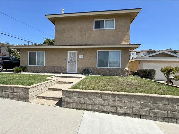 a front view of a house with garage and plants