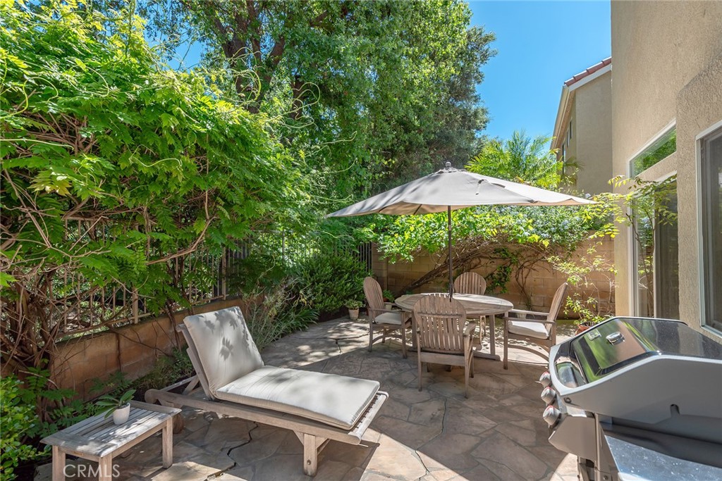4762 Rhapsody Drive Oak Park, CA 91377 - Photo 27 of 29 a view of a patio with chairs under an umbrella
