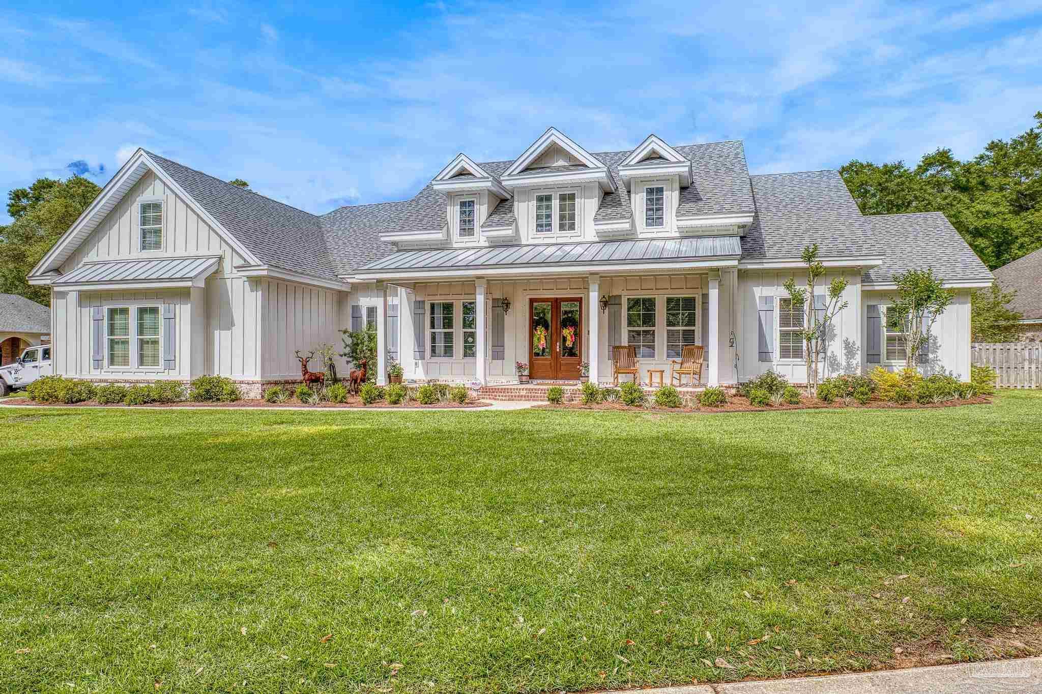 a front view of a house with a garden and yard