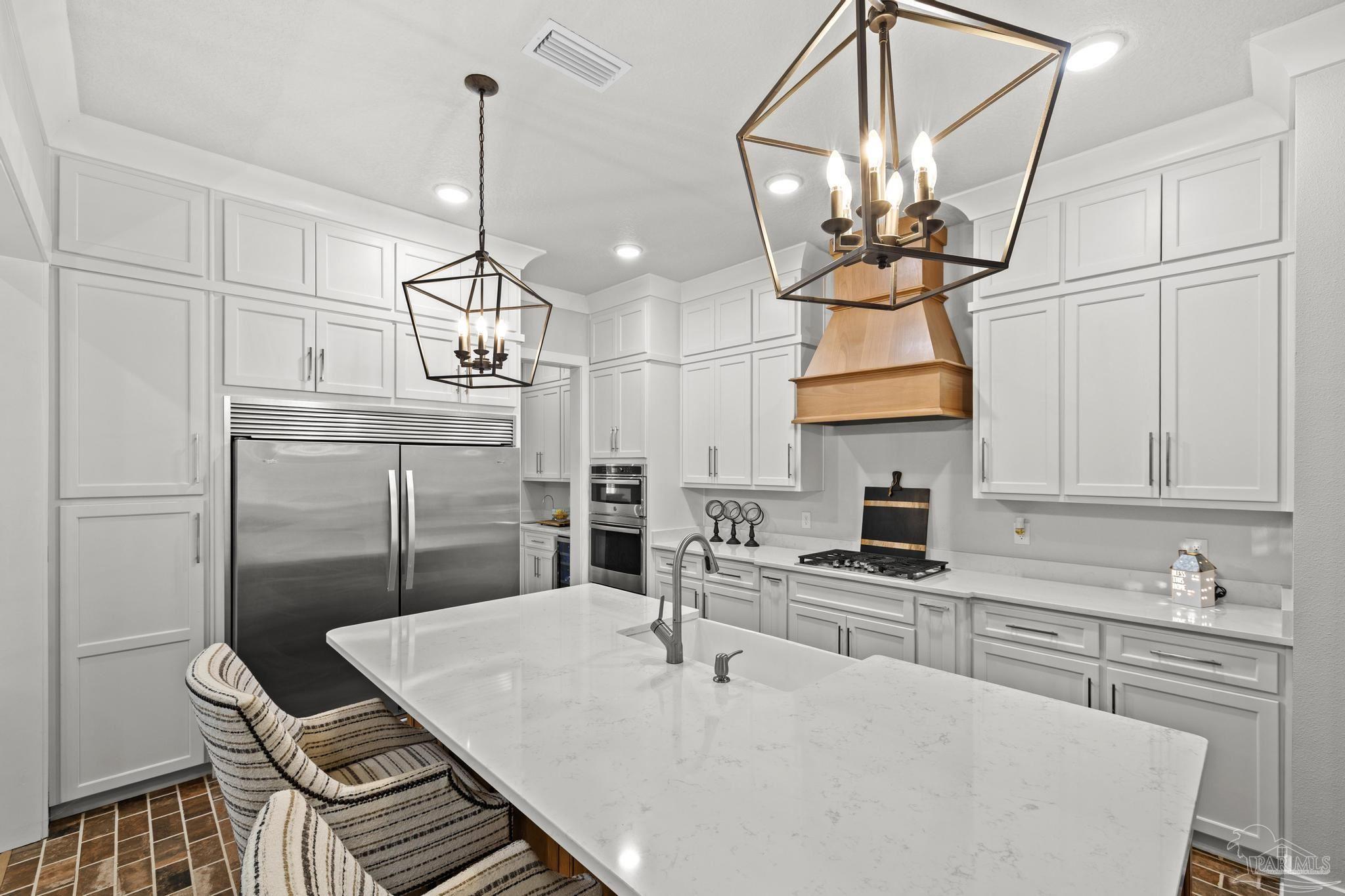 2031 Rambling Oaks Drive Cantonment, FL 32533 - Photo 14 of 62 a kitchen with stainless steel appliances granite countertop a sink a stove a refrigerator a dining table and chairs with wooden floor