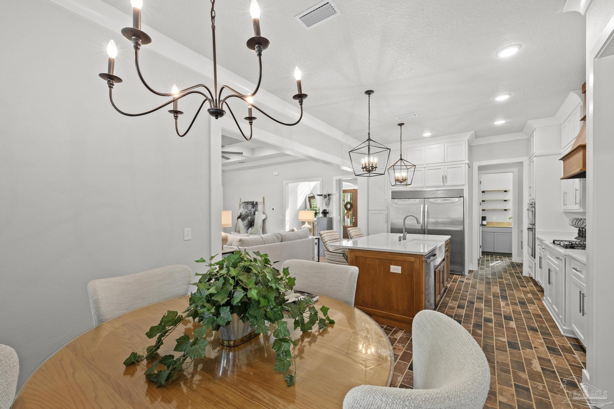 2031 Rambling Oaks Drive Cantonment, FL 32533 - Photo 19 of 62 a living room with furniture a chandelier and a dining table
