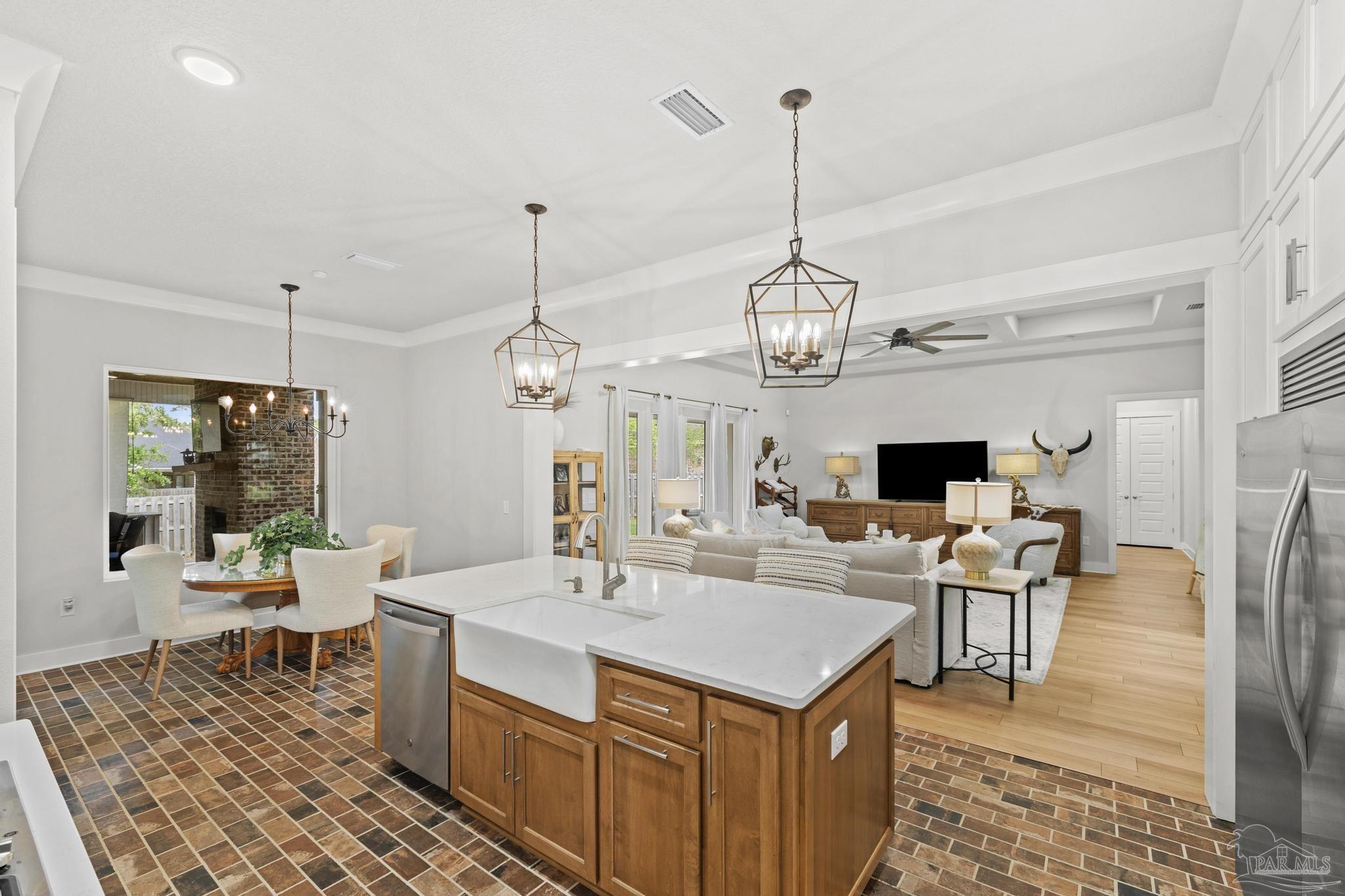 2031 Rambling Oaks Drive Cantonment, FL 32533 - Photo 20 of 62 a view of a dining room and livingroom with furniture wooden floor a rug a flat screen tv a rug and a chandelier