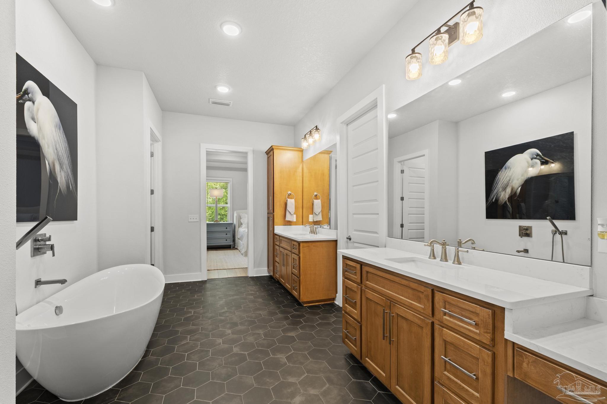 2031 Rambling Oaks Drive Cantonment, FL 32533 - Photo 30 of 62 a spacious bathroom with a bathtub sink and mirror