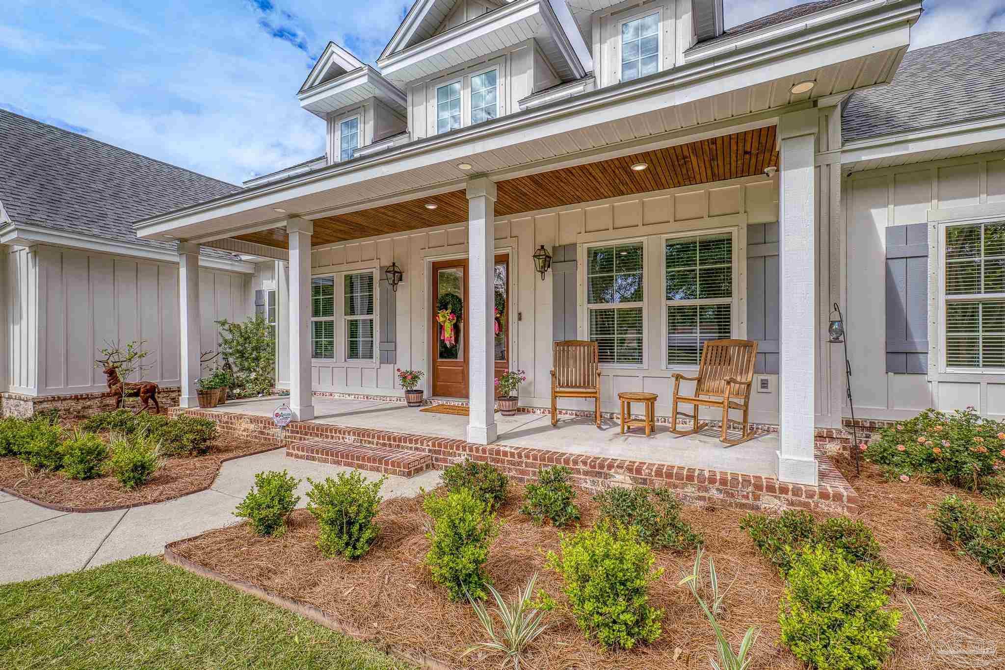 2031 Rambling Oaks Drive Cantonment, FL 32533 - Photo 3 of 62 front view of a brick house with a large window and potted plants