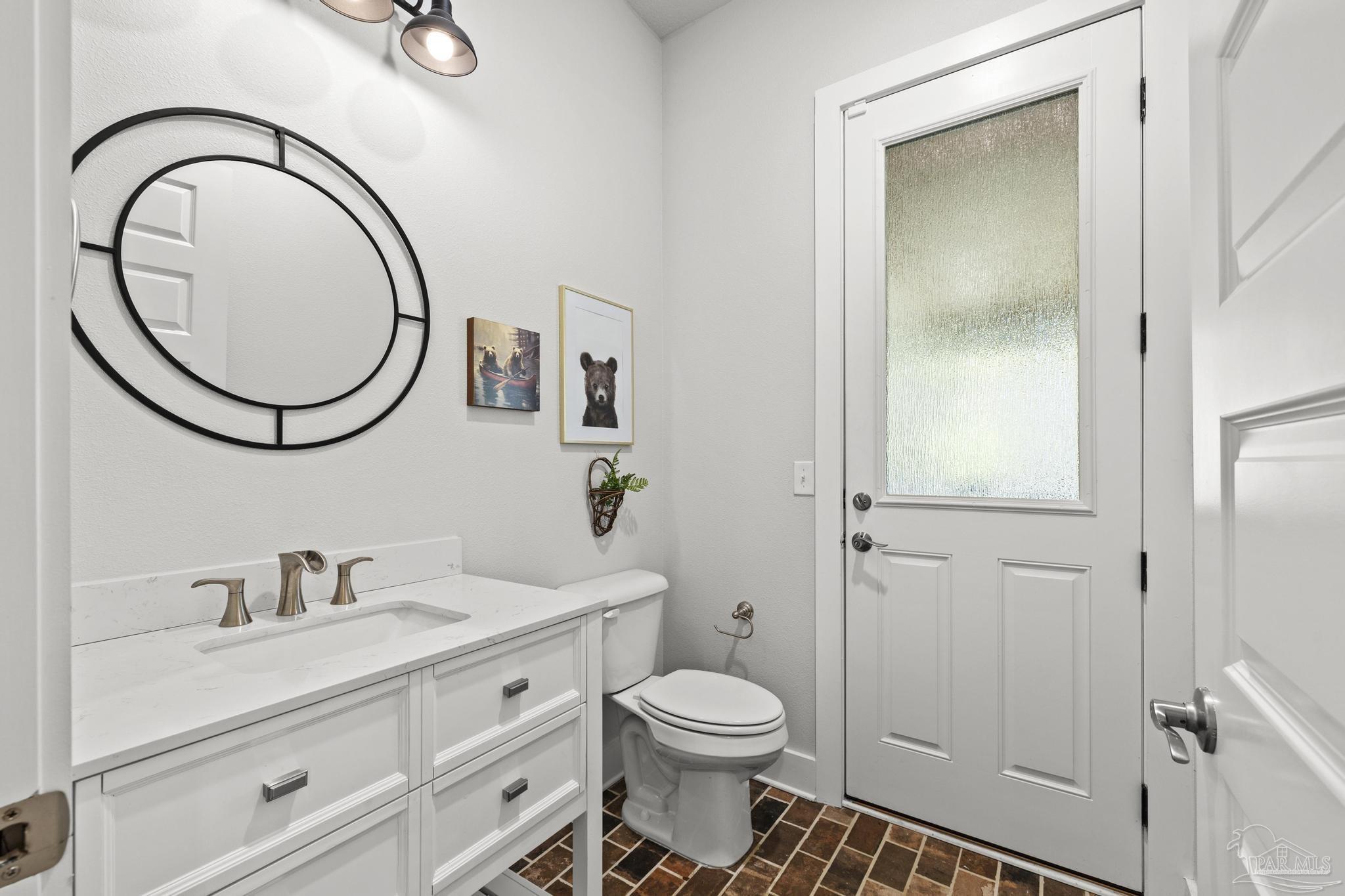 2031 Rambling Oaks Drive Cantonment, FL 32533 - Photo 49 of 62 a bathroom with a toilet a sink a mirror and vanity