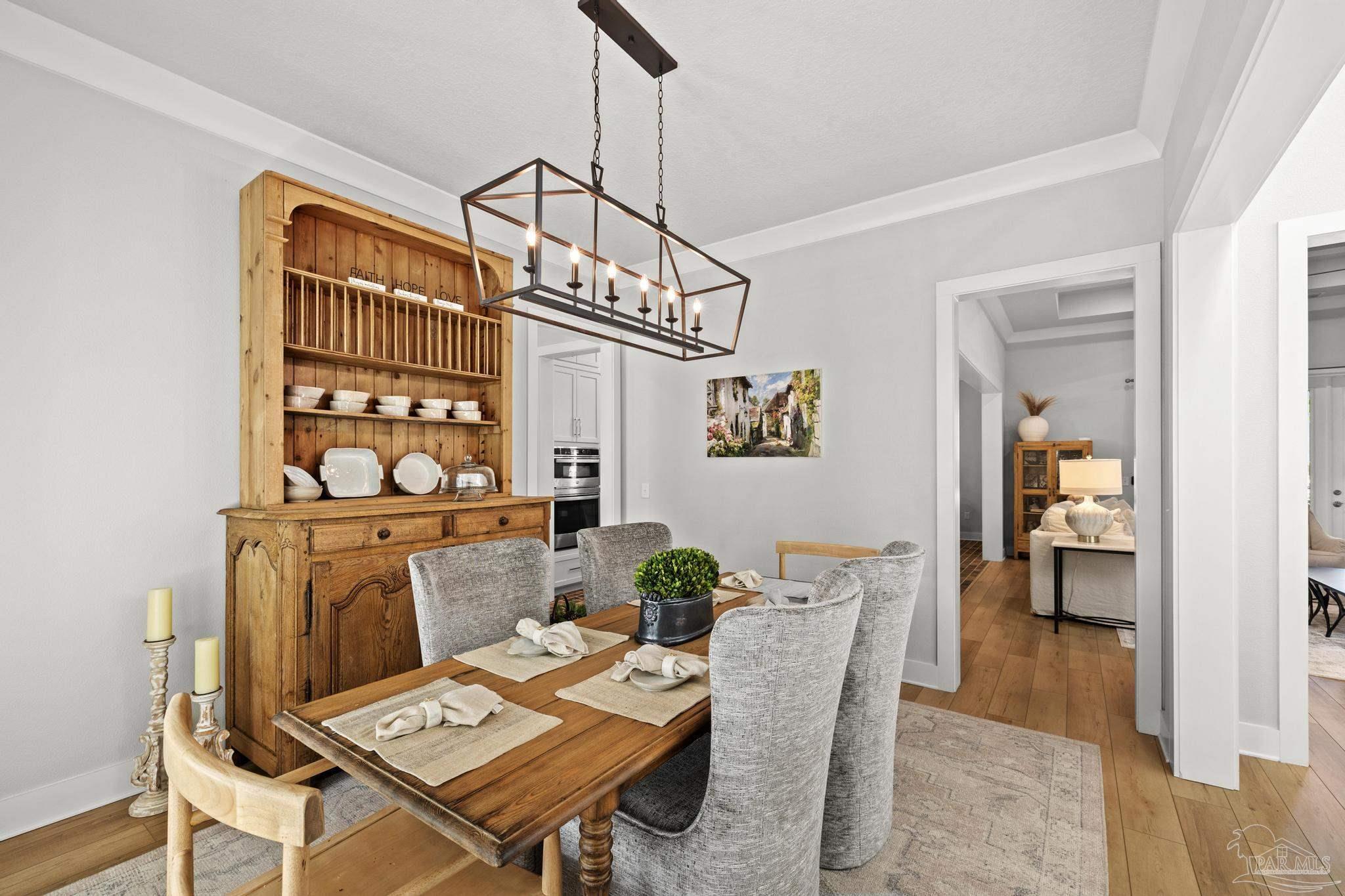 2031 Rambling Oaks Drive Cantonment, FL 32533 - Photo 8 of 62 a living room with furniture a rug and a chandelier