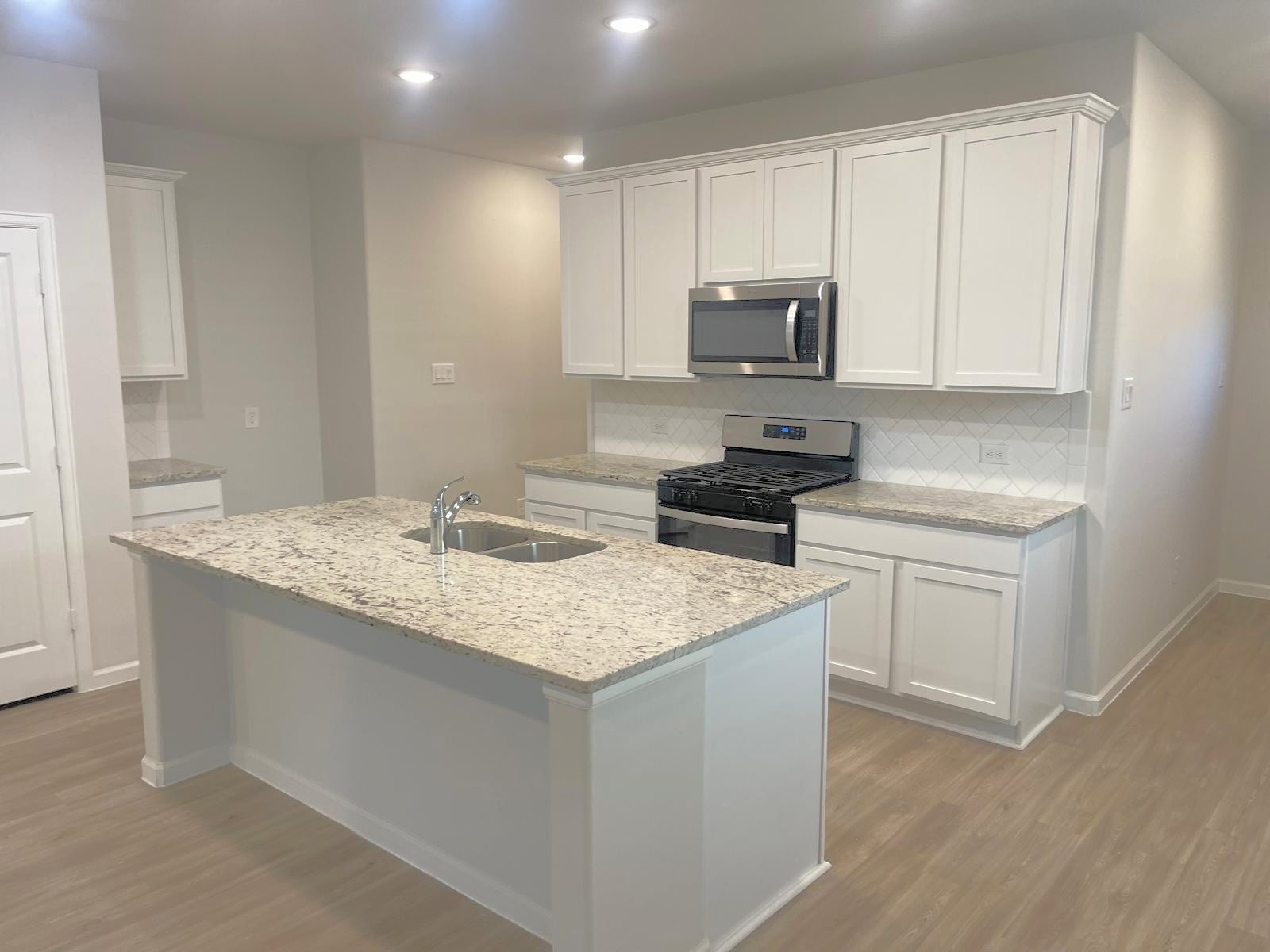 52 Valiant Ridge Trail Magnolia, TX 77354 - Photo 15 of 16 a kitchen with a sink stove and white cabinets
