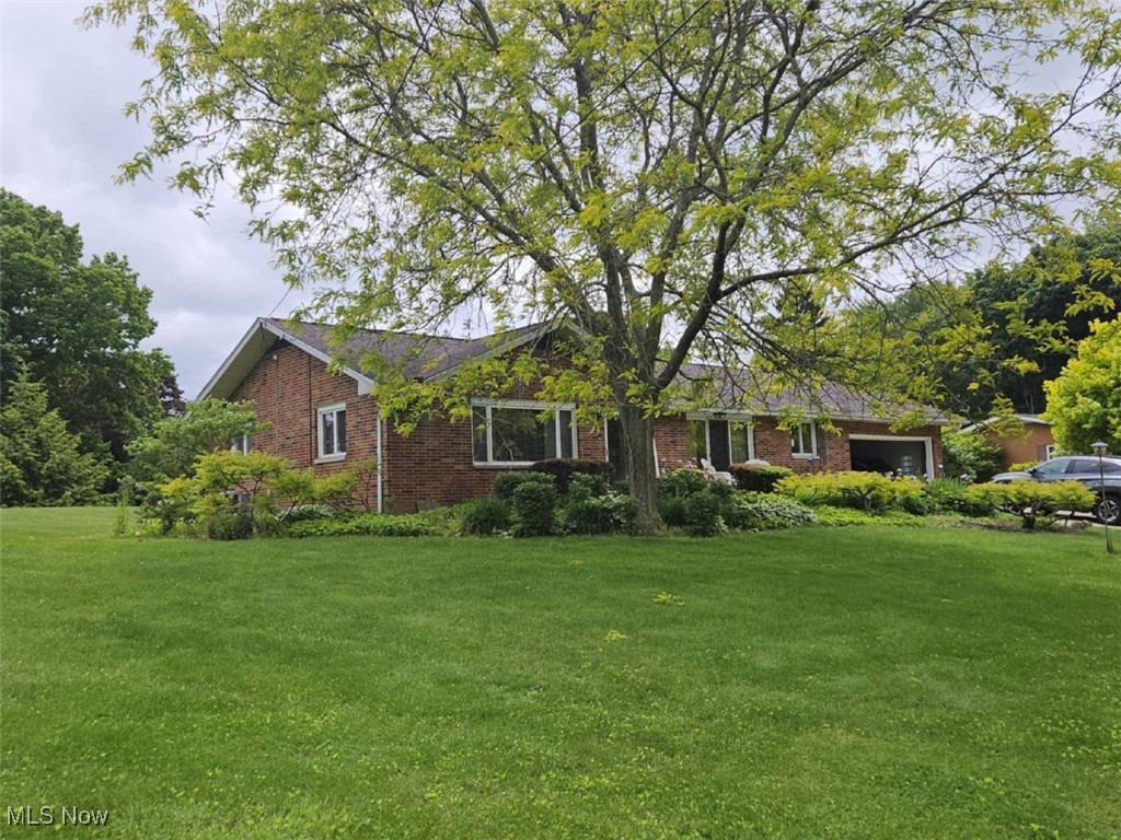 3084 Killian Road Uniontown, OH 44685 - Photo 2 of 38 Ranch-style home with brick siding, a garage, and a front yard