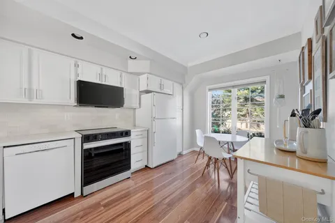 a kitchen with cabinets stainless steel appliances a sink and a window