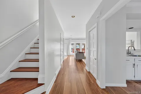a view of a hallway with wooden floor and staircase