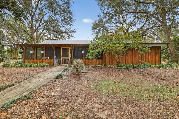 a front view of house with yard and trees around