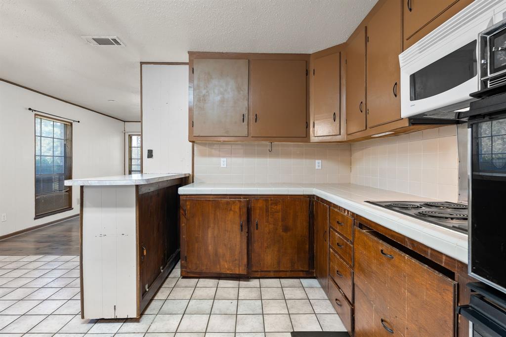 373 Ingred Street Waco, TX 76705 - Photo 11 of 39 a kitchen with stainless steel appliances granite countertop a sink stove and cabinets