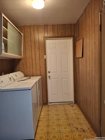 a utility room with a refrigerator and washer
