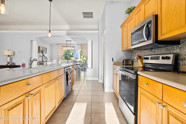 a large kitchen with stainless steel appliances granite countertop a stove a sink and a microwave