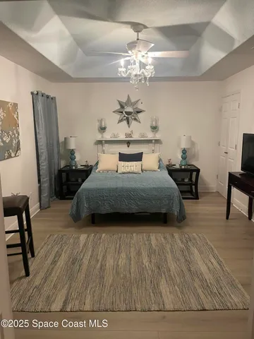 a spacious bedroom with a bed and a chandelier