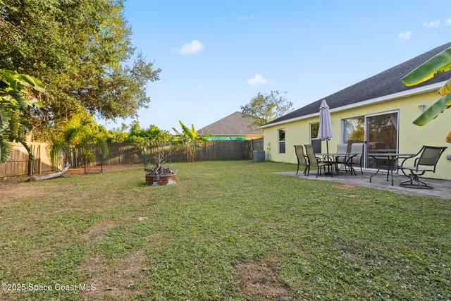 a backyard of a house with table and chairs