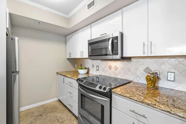 a kitchen with stainless steel appliances granite countertop a sink stove and microwave