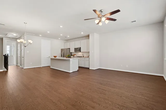an open kitchen with kitchen island white cabinets and stainless steel appliances