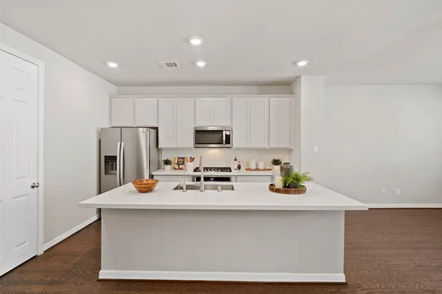 a kitchen with a refrigerator a stove a microwave and cabinets