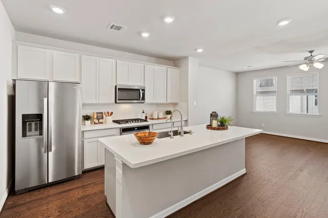 a kitchen with a sink a stove cabinets and wooden floor
