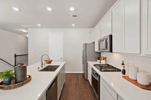 a kitchen with stainless steel appliances granite countertop a refrigerator and a stove