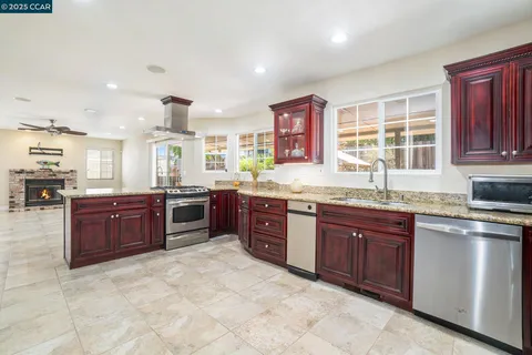 a large kitchen with stainless steel appliances granite countertop a stove sink and cabinets