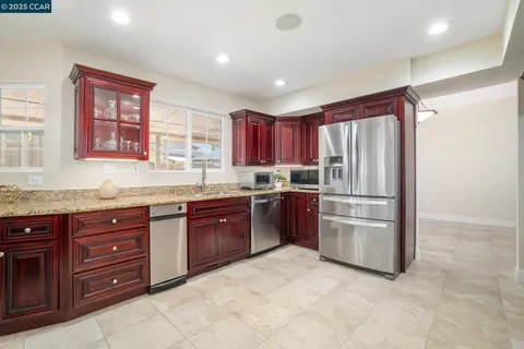 a kitchen with stainless steel appliances granite countertop a refrigerator and a sink