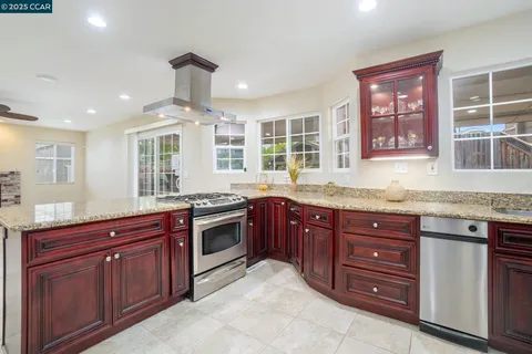 a kitchen with stainless steel appliances granite countertop wooden cabinets and a granite counter tops with a large window