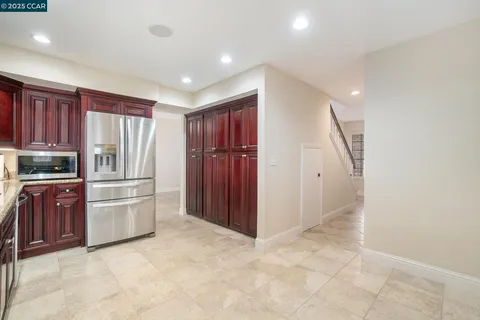 a kitchen with stainless steel appliances granite countertop a refrigerator and a stove top oven
