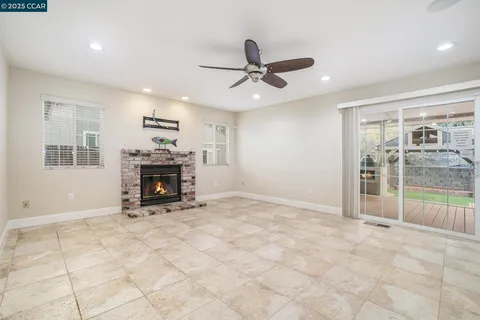 a view of empty room with fireplace and windows