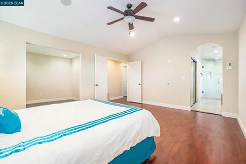 a spacious bedroom with a bed and a chandelier