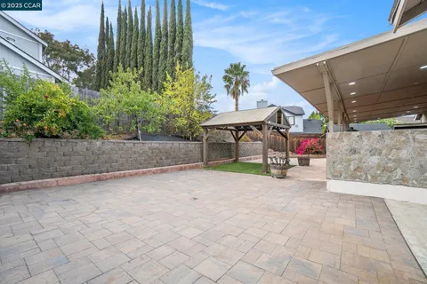 a view of a house with backyard and sitting area