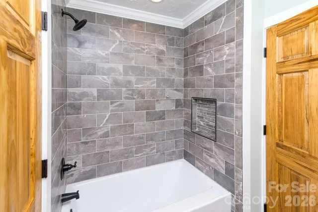 a view of an empty room with wooden floor and windows