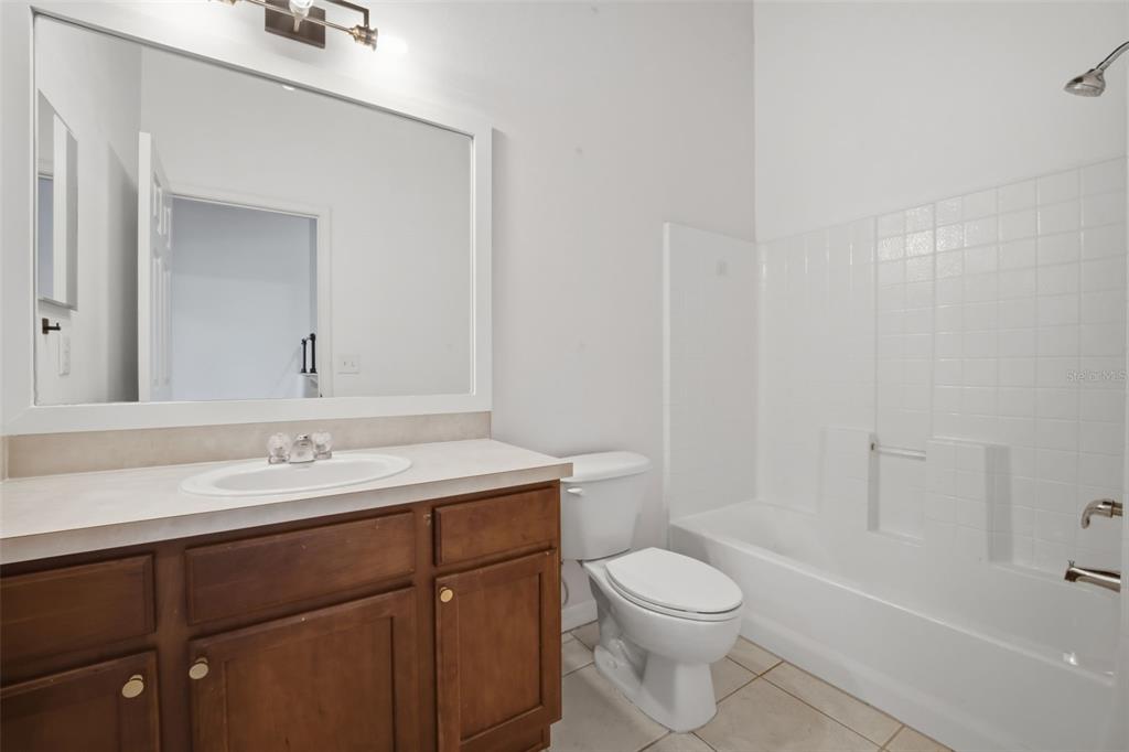 27547 Pleasure Ride Loop Wesley Chapel, FL 33544 - Photo 26 of 40 a bathroom with a granite countertop toilet a sink and a bathtub