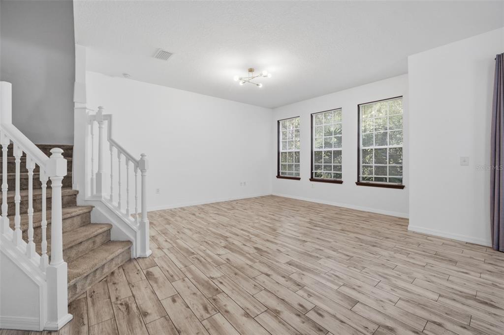 27547 Pleasure Ride Loop Wesley Chapel, FL 33544 - Photo 10 of 40 a view of an empty room with wooden floor and a window