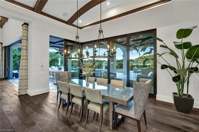 a view of dining room and livingroom with furniture wooden floor a chandelier