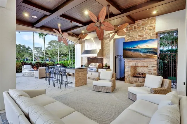 a front view of a building with outdoor seating and a palm tree