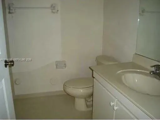a bathroom with a granite countertop toilet and a sink